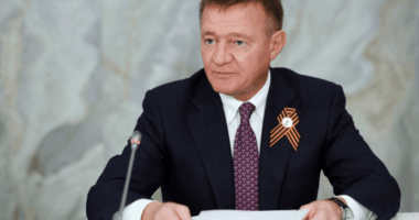 Man in suit reviewing documents.