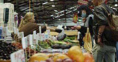 General photo of people shopping for fruits and vegetables at the Queen Vic Market.