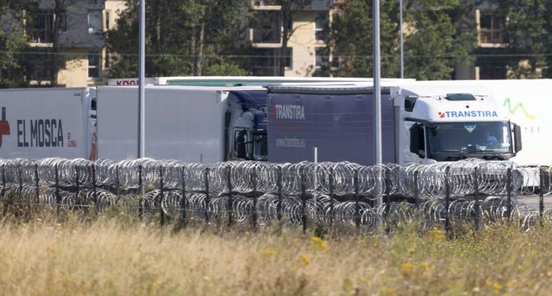 Trucks behind razor wire.