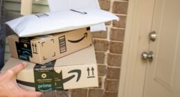 Person holding Amazon Prime packages at a front door.