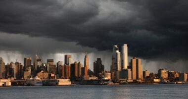 City skyline with storm clouds overhead.