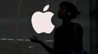A person walks past an Apple store in New York City
