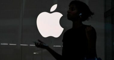 A person walks past an Apple store in New York City
