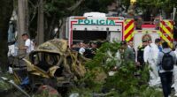 Aftermath of a vehicle explosion in Cali, Colombia; emergency responders and investigators at the scene.