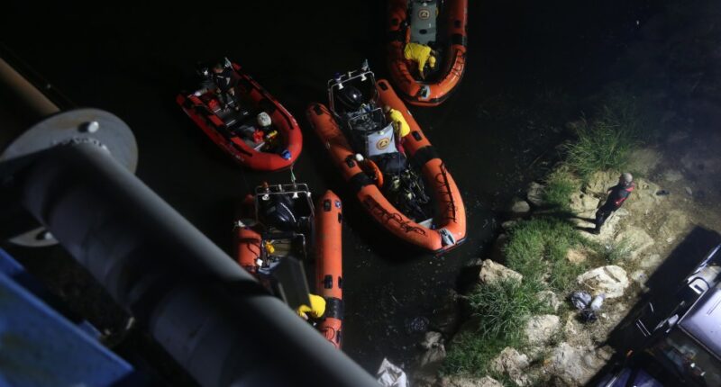 Search and rescue teams in inflatable boats at night.