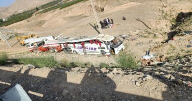 Bus crash scene with rescue workers.