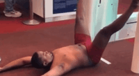 Man in red underwear lying on the floor at an airport gate.