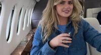 Woman seated in a private jet with two men in the background.