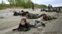 Students in camouflage uniforms participate in military training exercises.