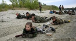 Students in camouflage uniforms participate in military training exercises.