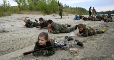 Students in camouflage uniforms participate in military training exercises.