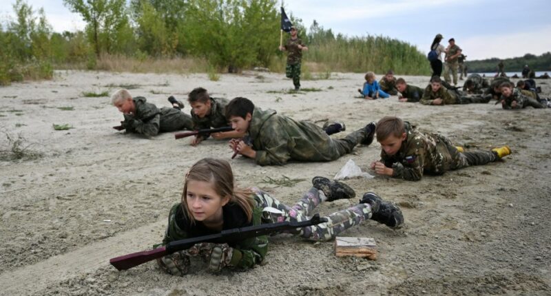 Students in camouflage uniforms participate in military training exercises.