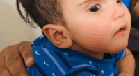 Photo of a baby wearing a blue shirt.