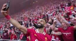 Liverpool's Mohamed Salah celebrates by taking a selfie after winning the English Premier League soccer match between Liverpool and Tottenham Hotspur and clinching the Premier League title at Anfield in Liverpool, England, Sunday, April 27, 2025. (AP Photo/Jon Super)