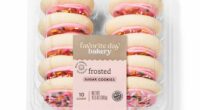 Ten frosted sugar cookies in a plastic container.