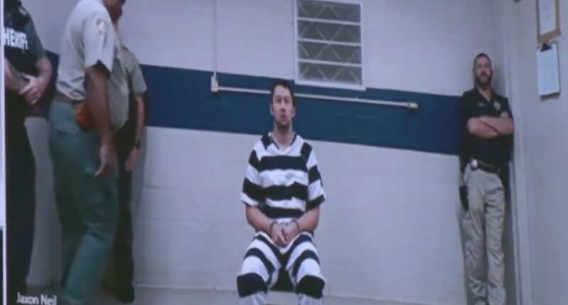 Screenshot of Jaxon Neil in a jail jumpsuit, flanked by officers.
