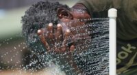 Paul Williams cools off in water while taking a break from yard work in Richardson, Texas, July 31, 2025. (AP Photo/LM Otero, File)