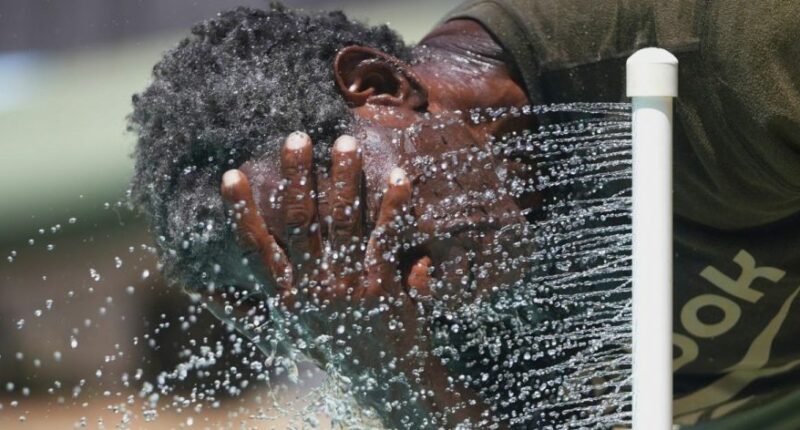 Paul Williams cools off in water while taking a break from yard work in Richardson, Texas, July 31, 2025. (AP Photo/LM Otero, File)