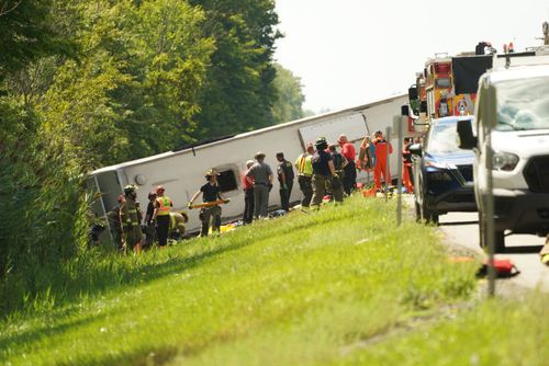 First responders work to rescue victims at the scene of a tour bus that crashed and rolled over on the New York State Thruway.