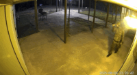Surveillance video still image of a person in camouflage at night.