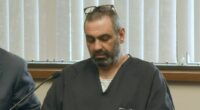 Man in dark shirt at court hearing.