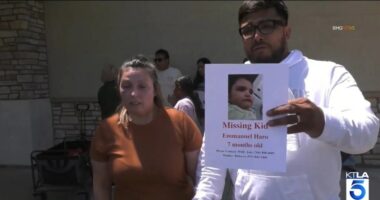 Couple holding a missing child poster.