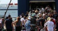 Passengers waiting at a ferry terminal with luggage.
