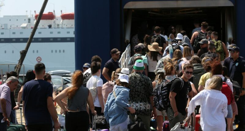 Passengers waiting at a ferry terminal with luggage.