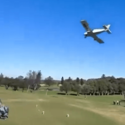 Small plane making an emergency landing on a golf course.
