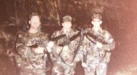 Three soldiers in camouflage uniforms holding rifles.