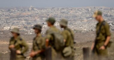 Israeli soldiers observing destroyed buildings in the Gaza Strip.