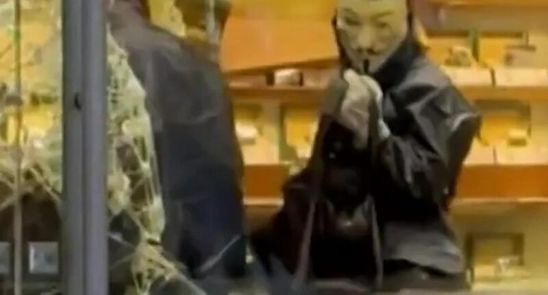 Person in Guy Fawkes mask during Ginza robbery.