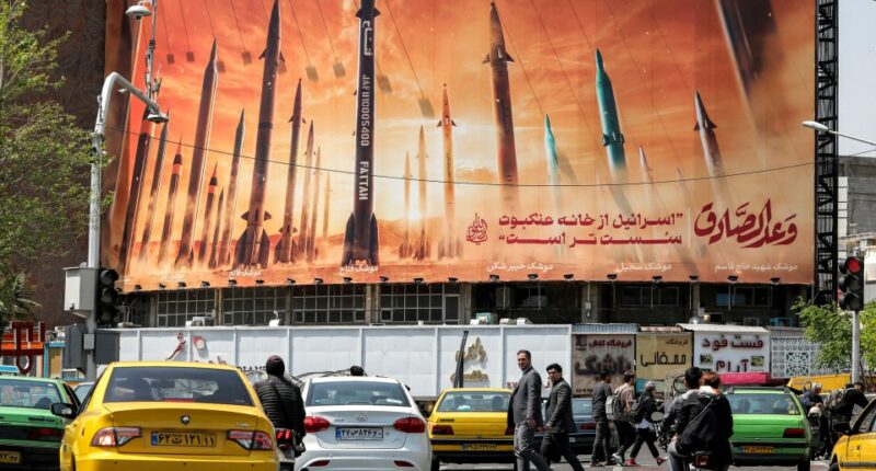 Billboard depicting Iranian ballistic missiles; text reads "Israel is weaker than a spider's web".