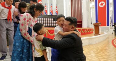 Kim Jong Un embracing children of fallen soldiers at an award ceremony.