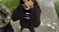 Teenager in black sweatshirt posing outdoors.