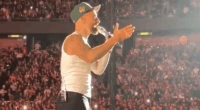 Singer performing on stage in front of a large crowd.