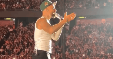 Singer performing on stage in front of a large crowd.
