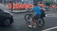 Moment vigilante Cycing lMikey pushes his bicycle into a car amid row