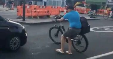 Moment vigilante Cycing lMikey pushes his bicycle into a car amid row