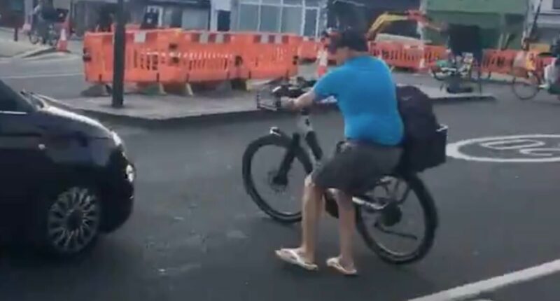 Moment vigilante Cycing lMikey pushes his bicycle into a car amid row