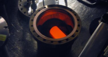 A circular metal container with a glowing cylinder inside.