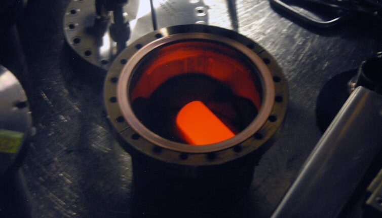A circular metal container with a glowing cylinder inside.