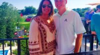 Woman and young man smiling for a photo on a patio overlooking a golf course.