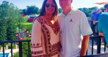 Woman and young man smiling for a photo on a patio overlooking a golf course.