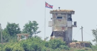 A soldier stands at a North Korean military guard post flying a national flag, seen from Paju, South Korea, in June 2024.