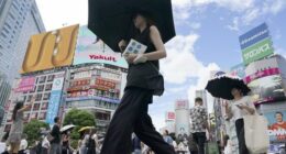 People walk along Shibuya scramble crossing under hot and sunny weather, Wednesday, Aug. 28, 2024, in Tokyo. (AP Photo/Eugene Hoshiko)