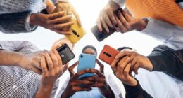 Teens in circle holding smart mobile phones - Multicultural young people using cellphones outside - Teenagers addicted to new technology concept
