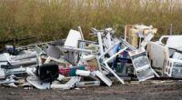 Pile of discarded appliances and furniture at a rubbish dump.