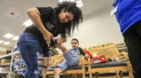 Isaiah Moctezuma, 6, tries on a new pair of New Balance tennis shoes with help from his mother, Kat, at Shoe Stop while shopping for back-to-school shoes provided by the Danheiser Fund for Kids, Saturday, Aug. 2, 2025, in Owensboro, Ky. (Greg Eans/The Messenger-Inquirer via AP)