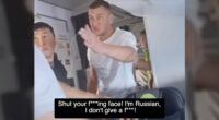 A man on an airplane yelling at another passenger.